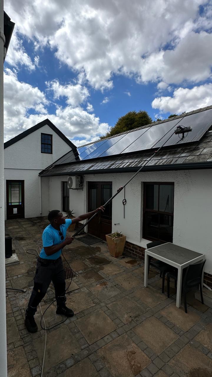 Blu cleaner washing windows at a Cape farmhouse with rooftop solar panels